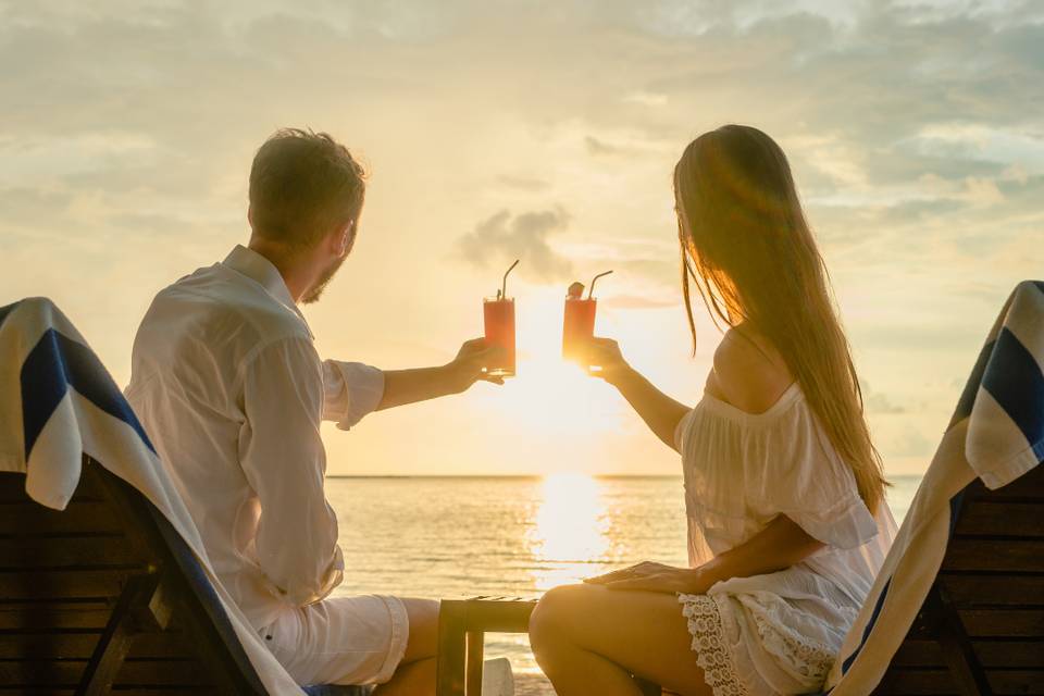 Brindis romántico frente al atardecer