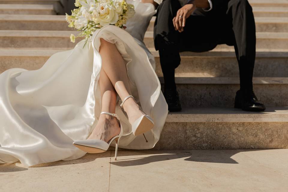 Piernas de novia y zapatos de novio en una escalera
