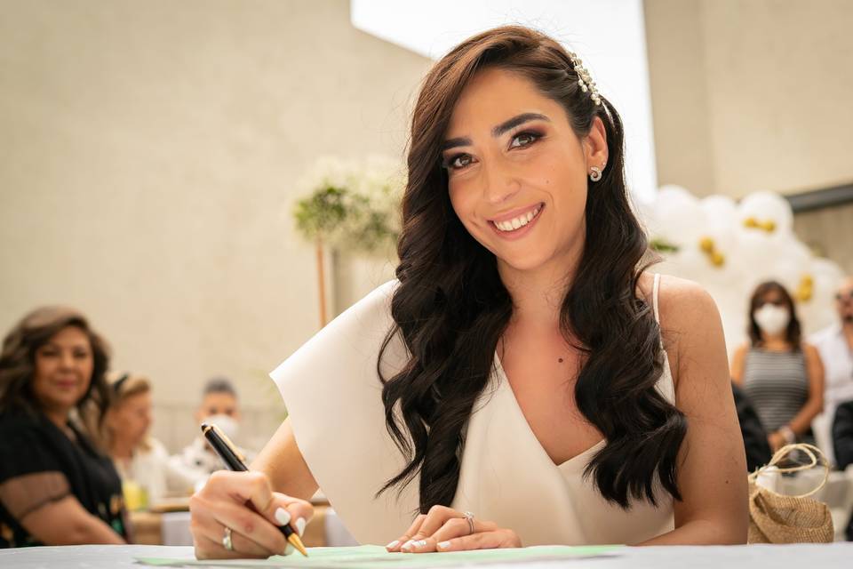 Novia sonriendo mientras firma