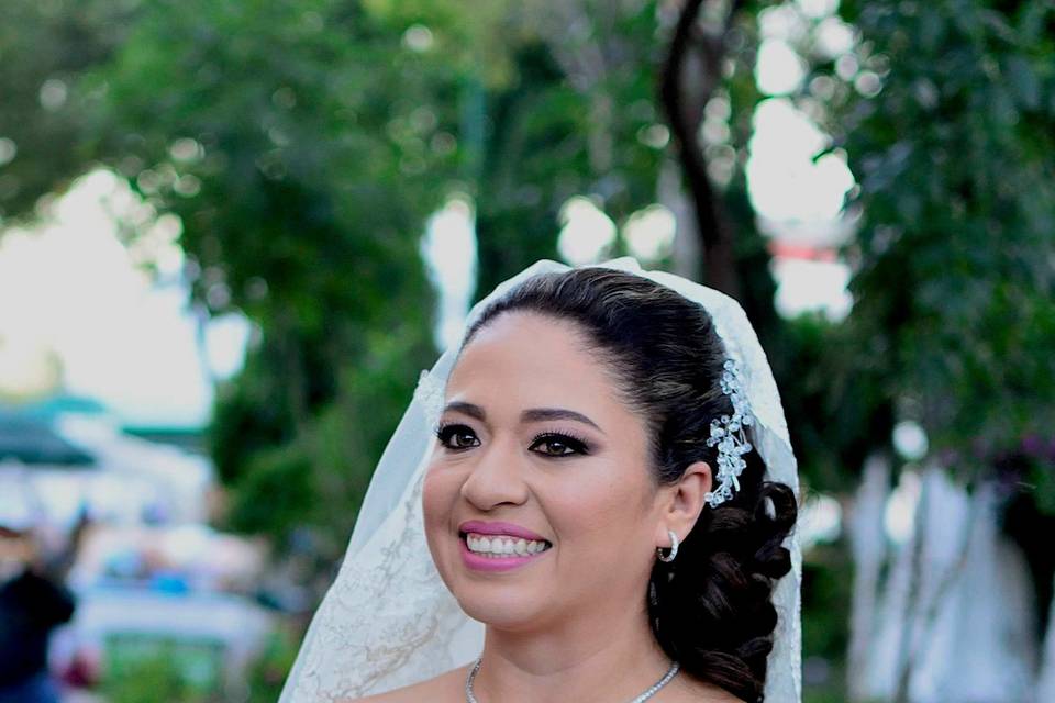 Novia sonriendo con un ramo de flores moradas