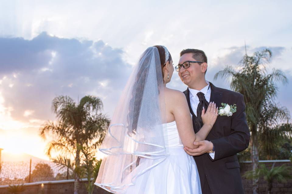 Novios sonriendo en el atardecer