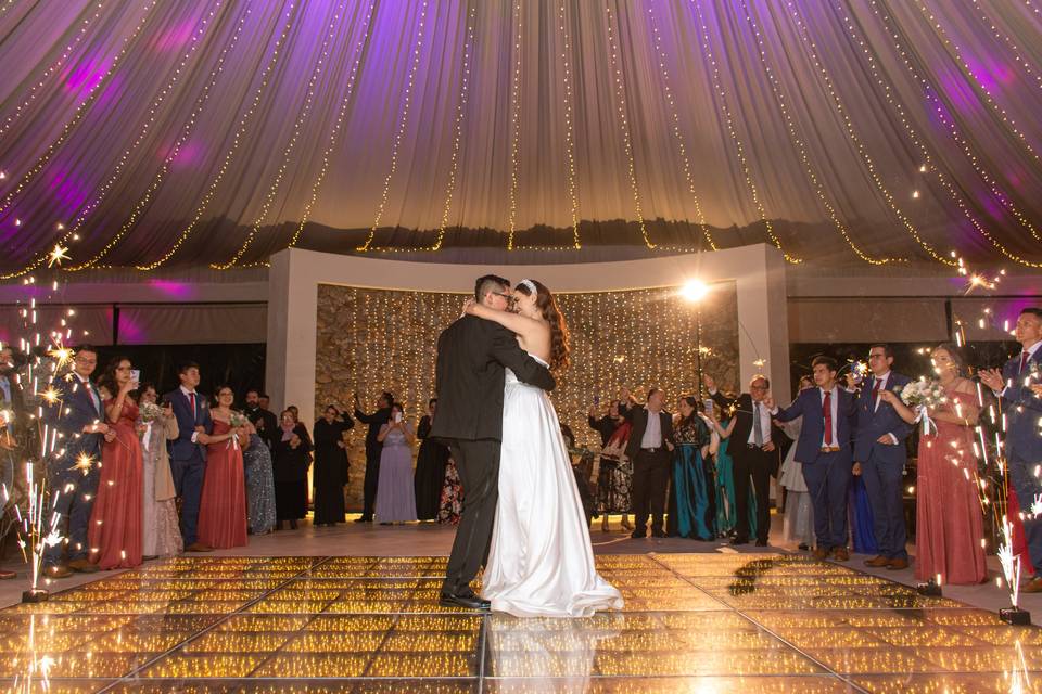 Novios bailando en la pista frente a los invitados