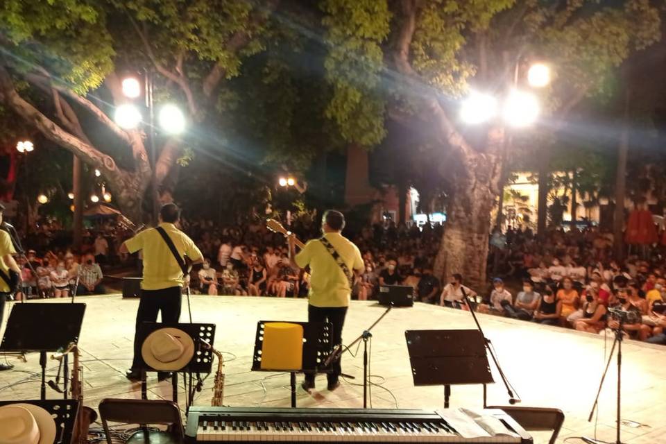 Trío tocando en un escenario al aire libre