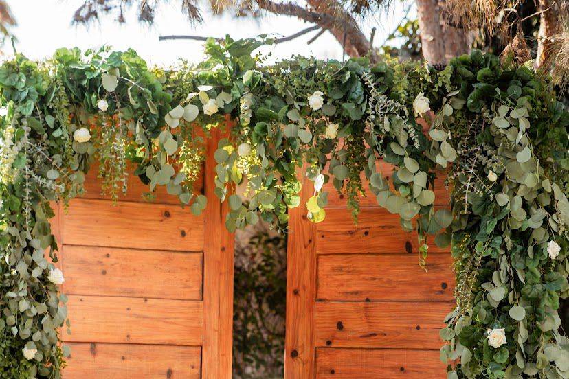 Mesa adornada con un back de puertas de madera y flores