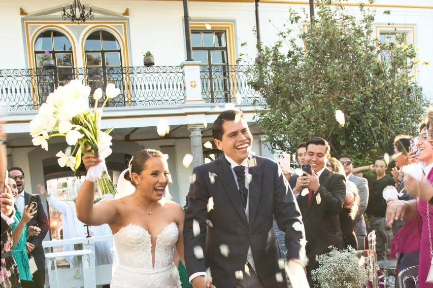 Recién casados festejando mientras caminan por el pasillo al altar