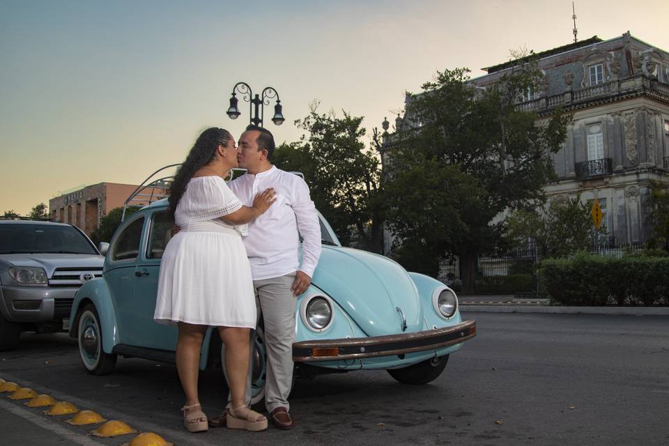 Pareja besándose frente a un vochito