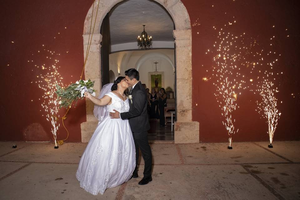 Novios besándose frente a la iglesia