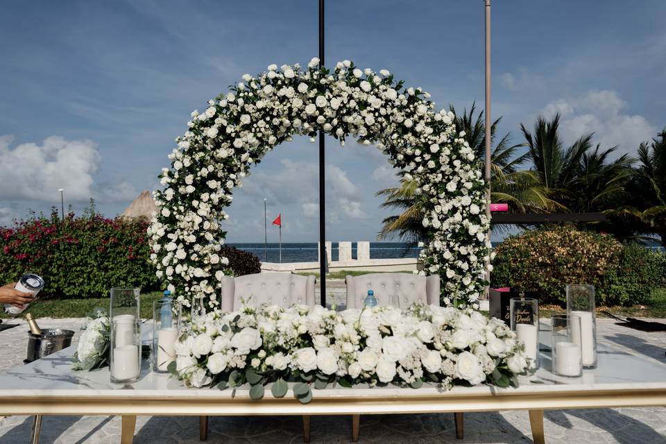 Mesa de novios con un back de flores blancas