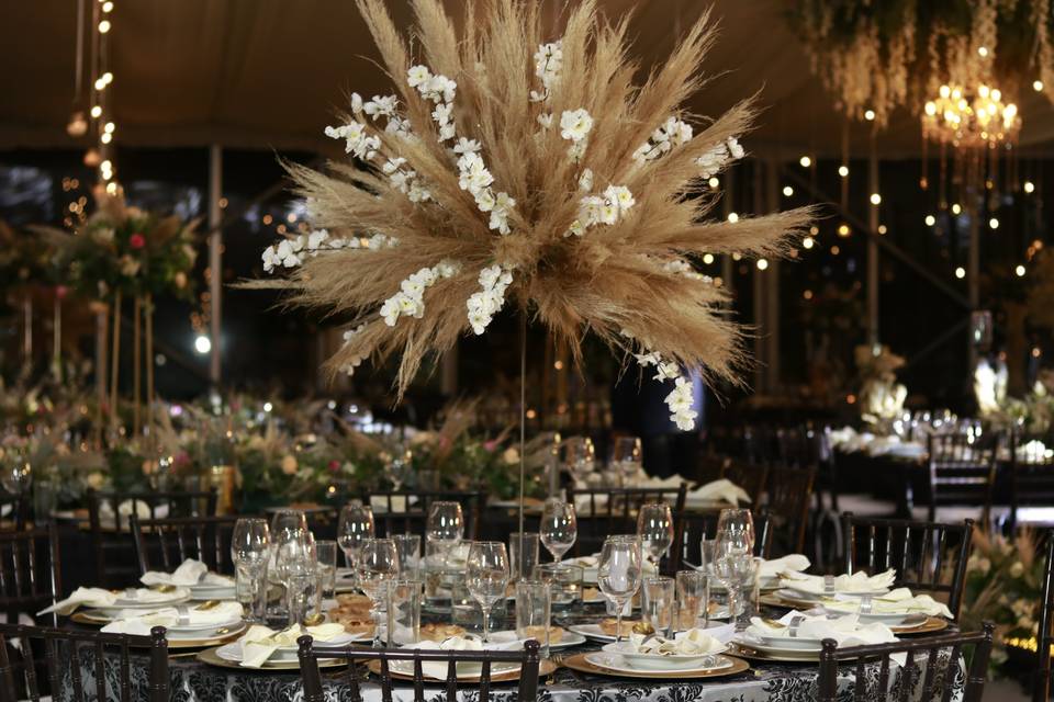 Arreglo floral alto en una mesa decorada elegantemente