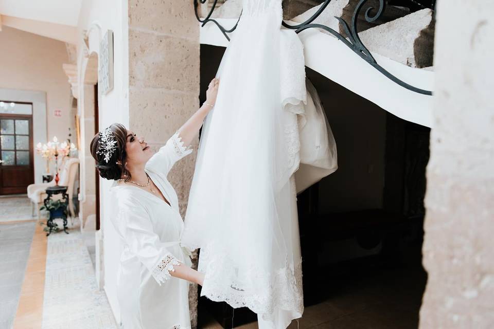 Novia mirando su vestido colgado