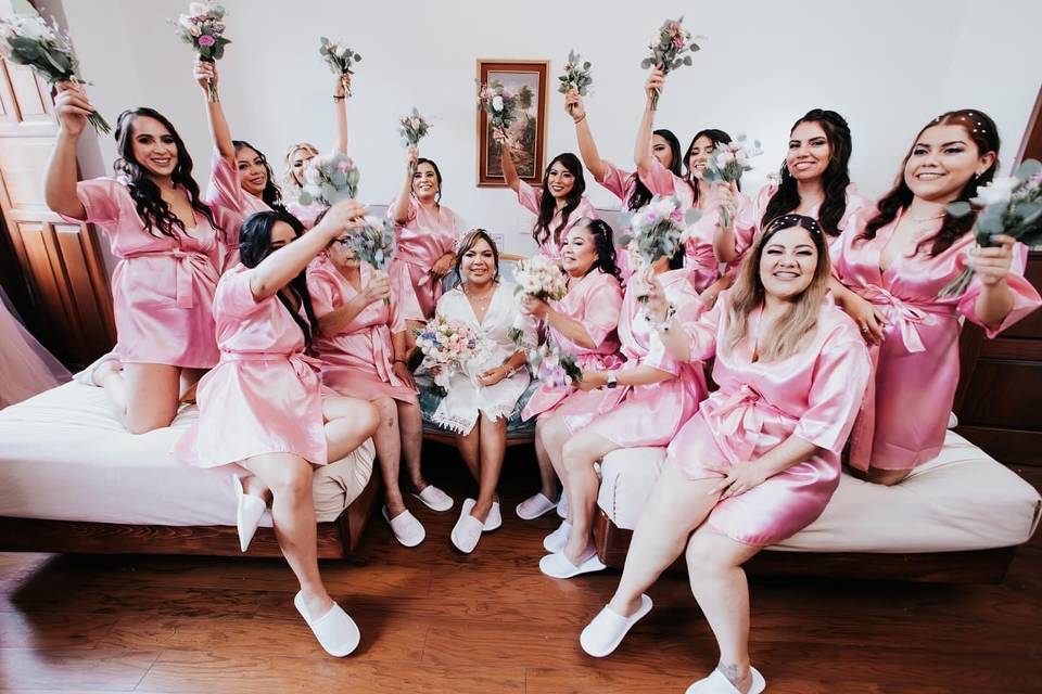 Damas de honor en bata rosa alrededor de la novia