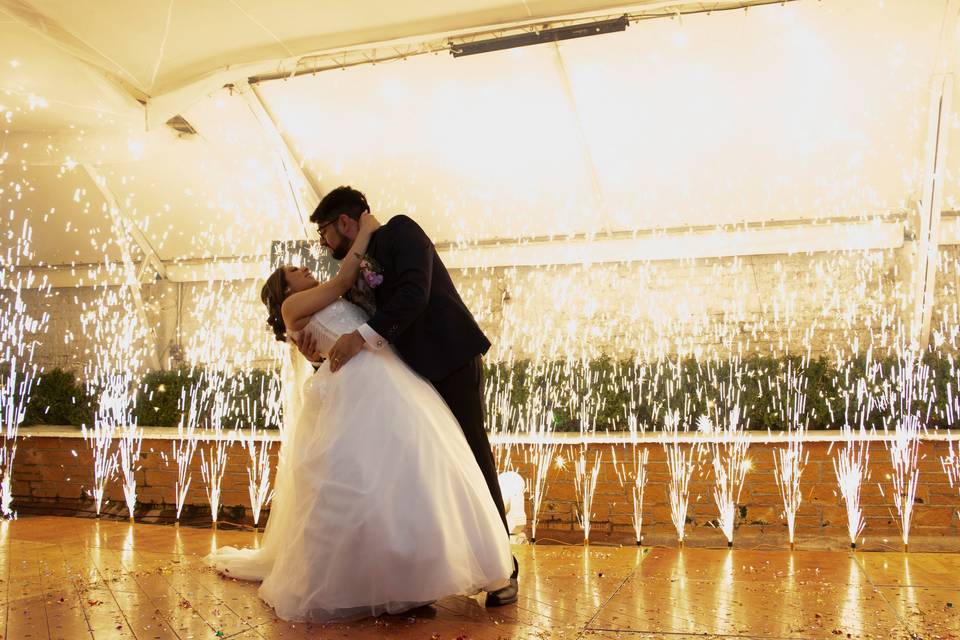 Novios bailando en la pista con chisperos de dulces