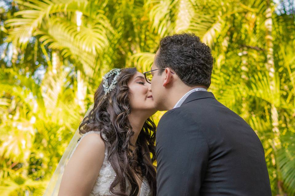 Novios dándose un beso y agarrados de la mano