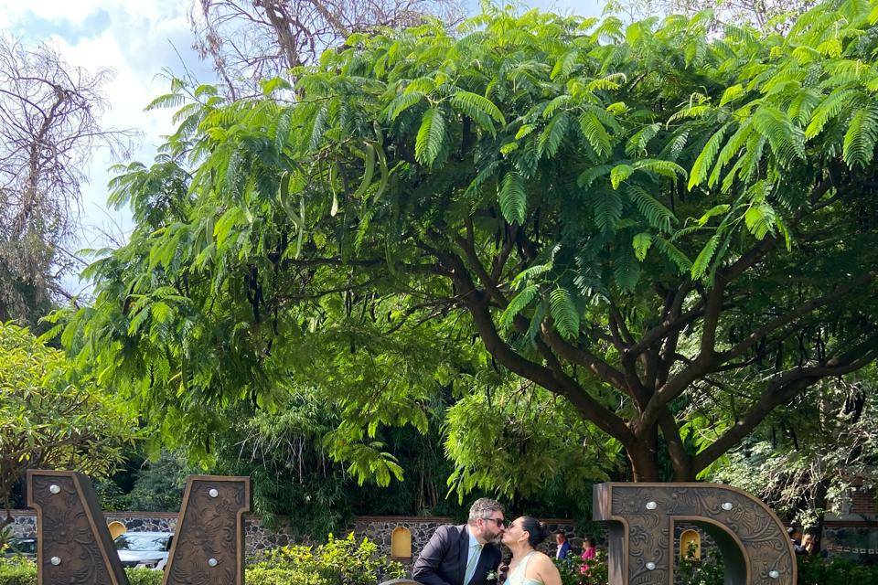 Pareja en el jardín posando con letras