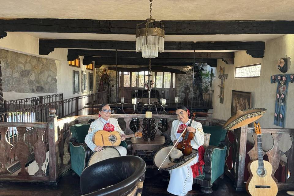 Dos mariachis sentadas con sus instrumentos