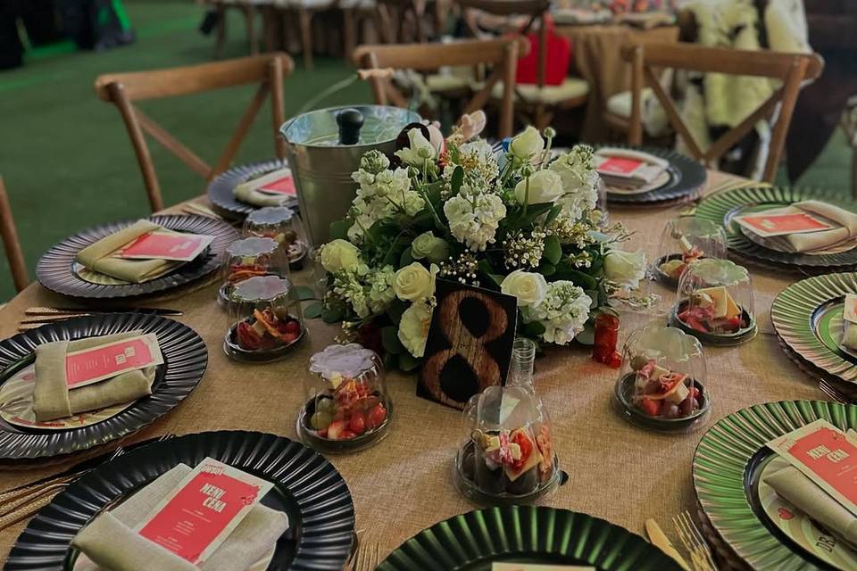 Montaje de mesa con platos oscuros y servillas blancas