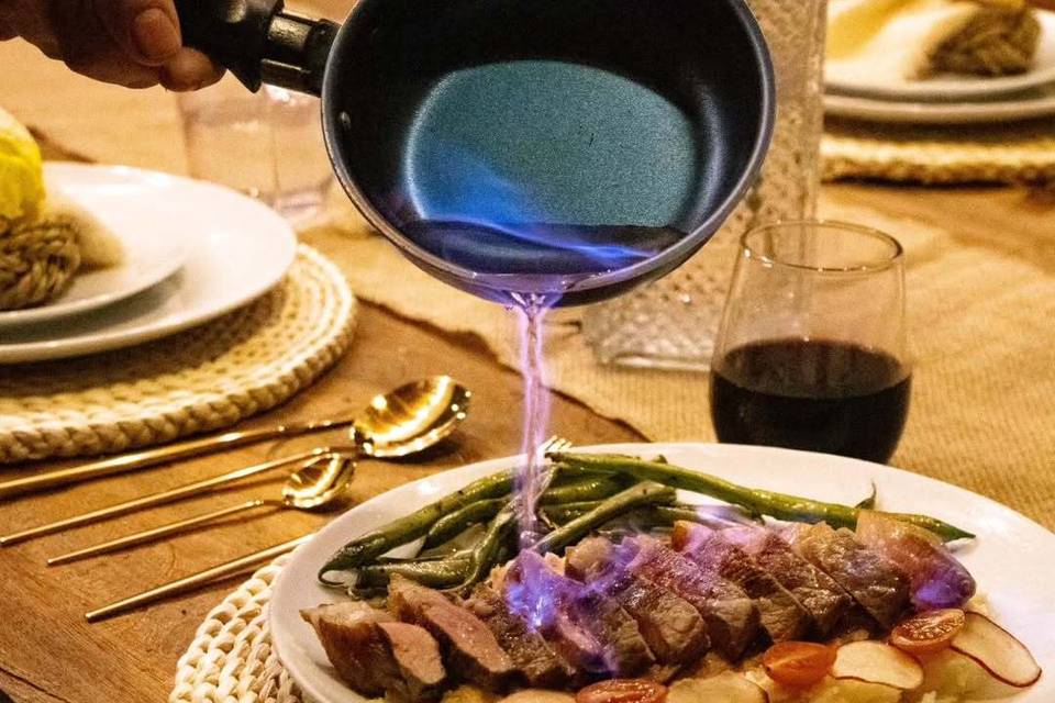 Plato de carne con papas echándole una salsa