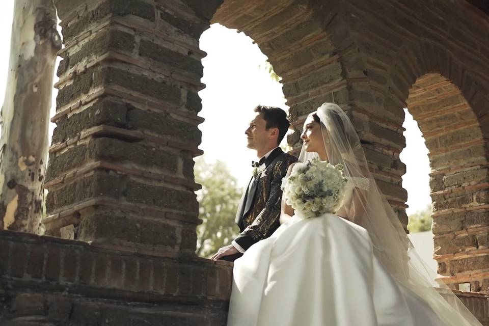 Novios sentados en unos arcos