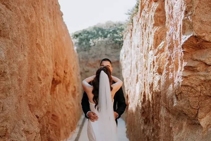 Novios besándose en medio de las rocas