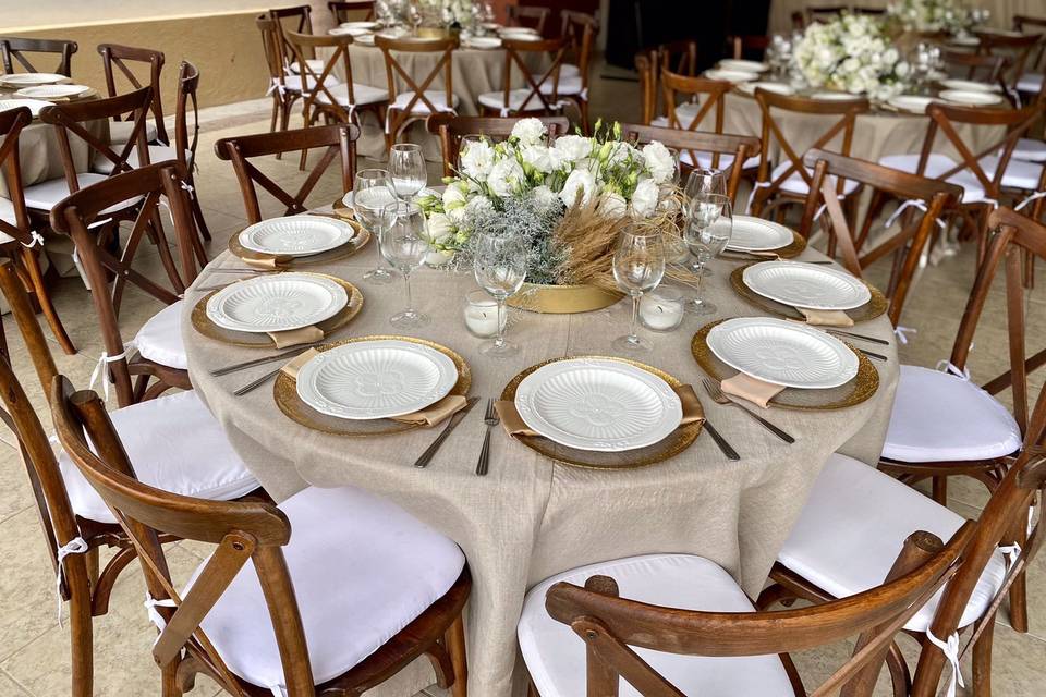 Mesa con platos blancos y manteles beige