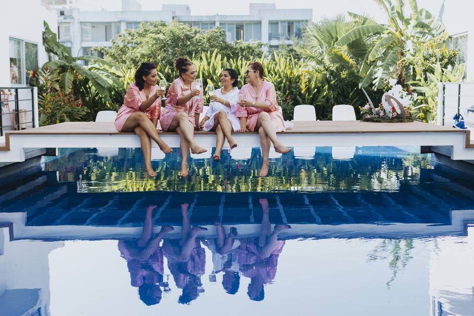 Novia con damas de honor en bata en una alberca