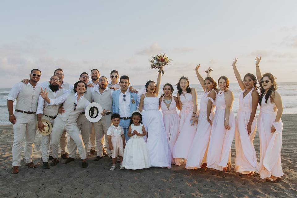 Novios en la playa con sus damas de honor y bestmen