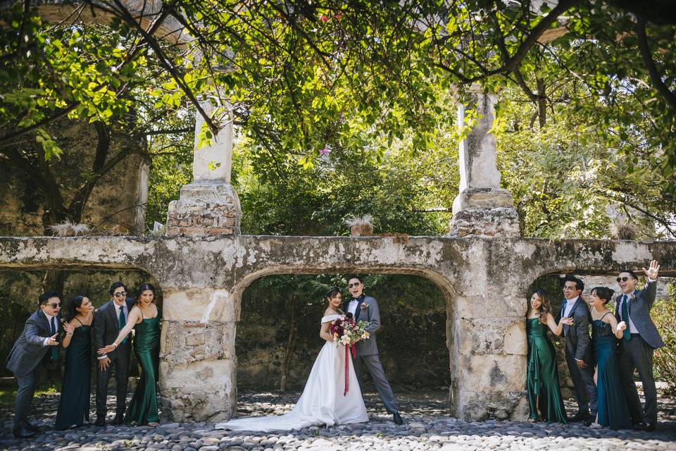 Novios posando en un patio con sus damas de honor y bestmen