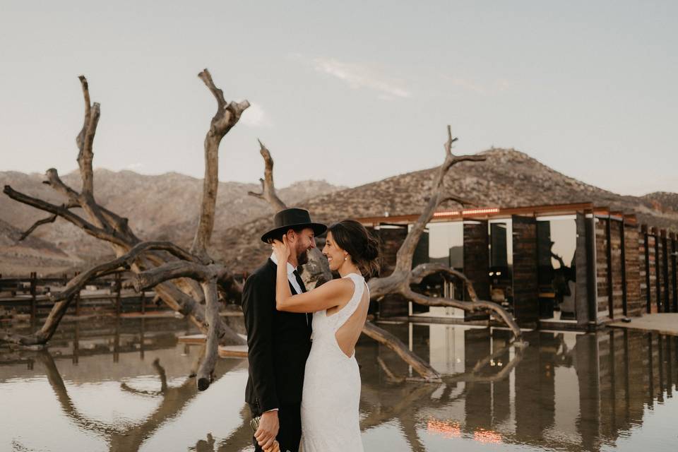 Novios abrazados frente a un lago