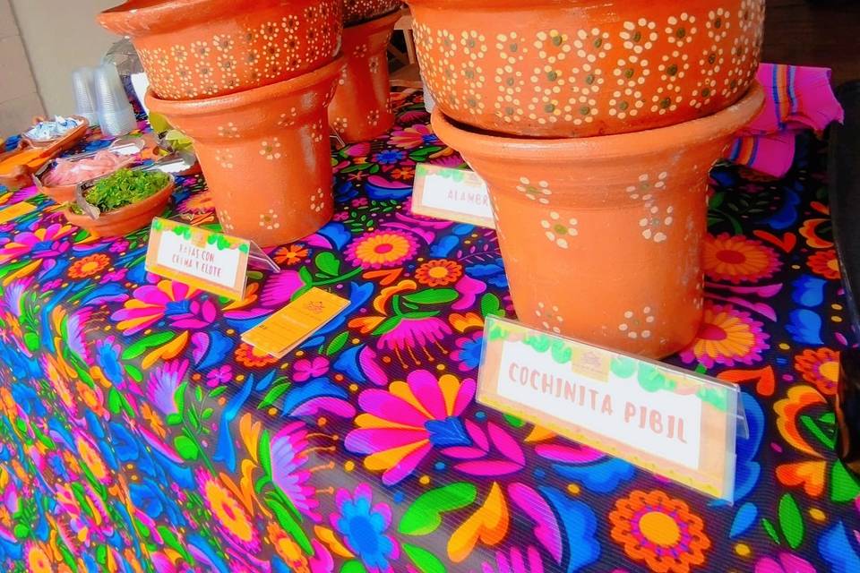 Cazuelas con comida sobre mesa de colores