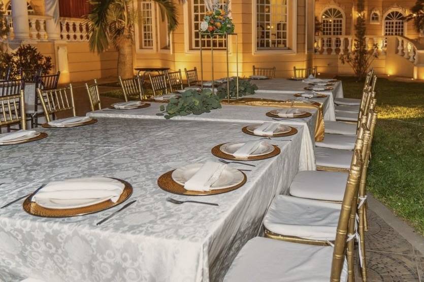 Mesa con mantel blanco y platos dorados
