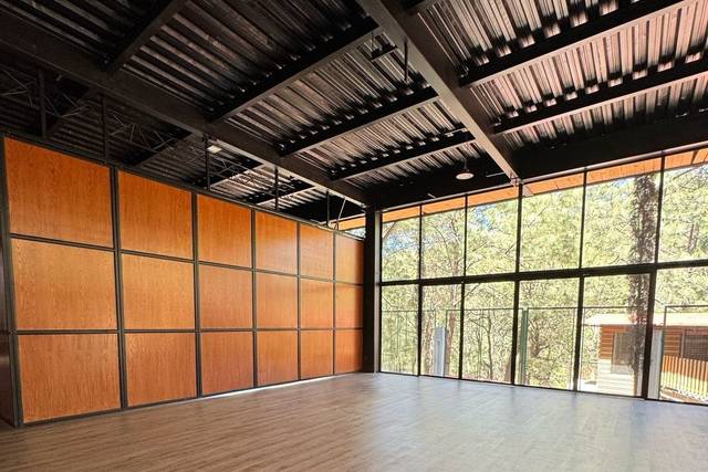 Salón con suelo de madera y ventanales