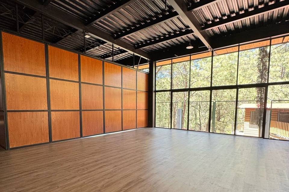 Salón con suelo de madera y ventanales