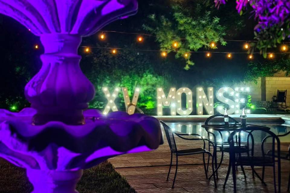 Fuente iluminada y letras gigantes de fondo