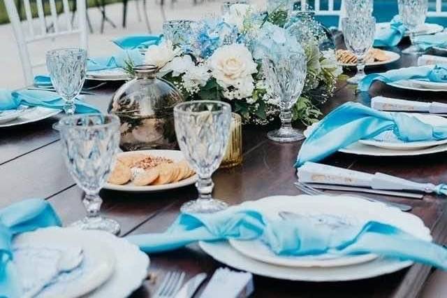 Copas de cristal con vajilla blanca y mantelería azul