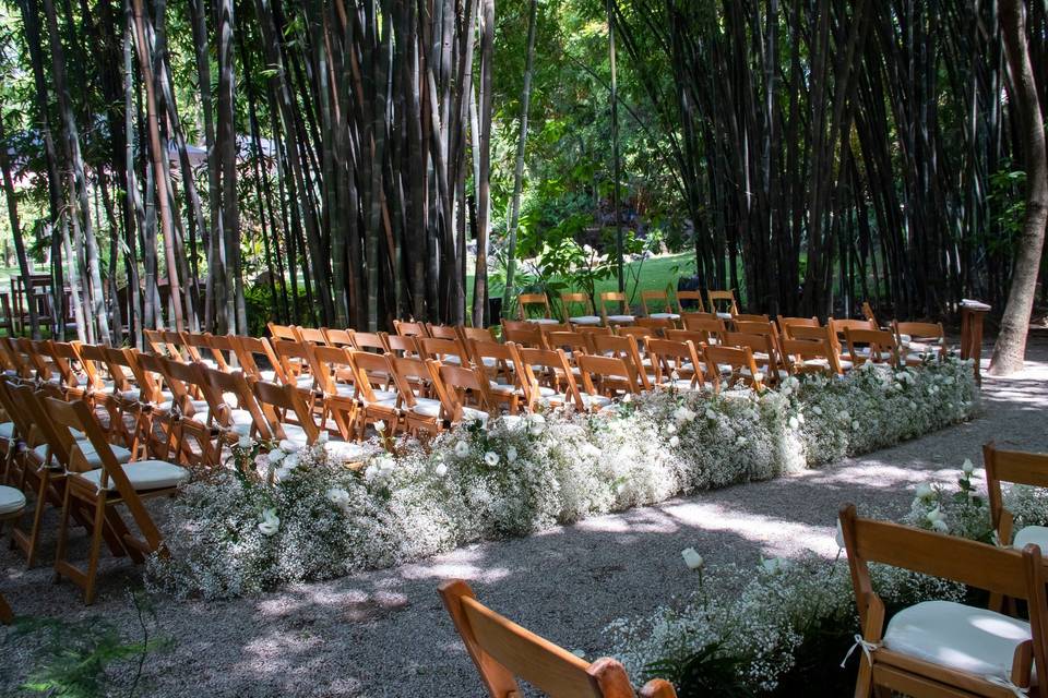 Sillas para ceremonia con arreglos florales blancos