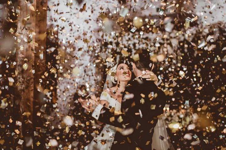 Novios bailando en medio de papelitos