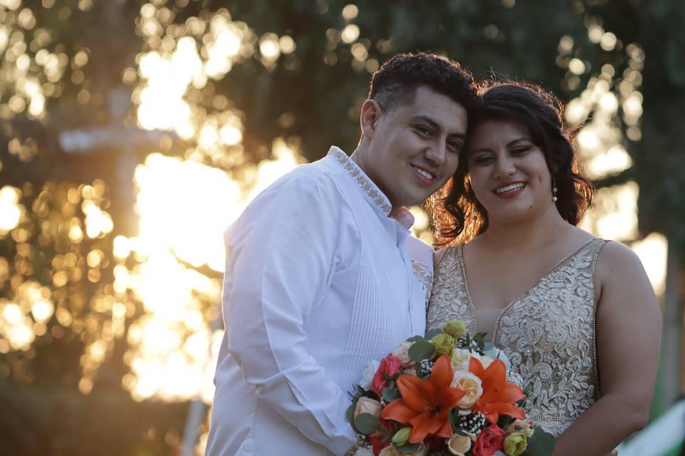 Novios posando al aire libre en el atardecer