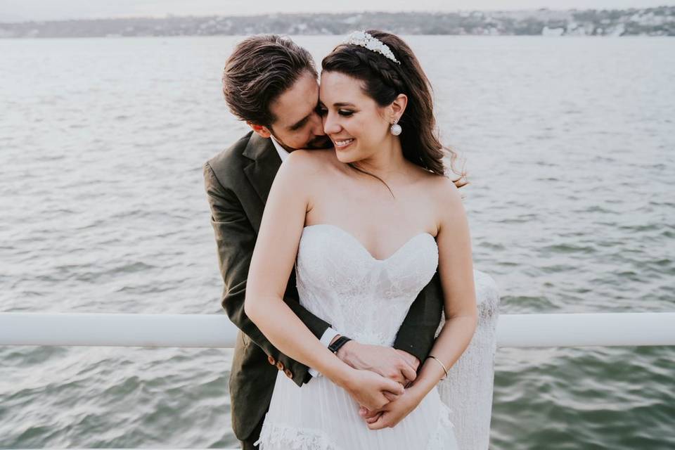 Novios abrazados frente al mar