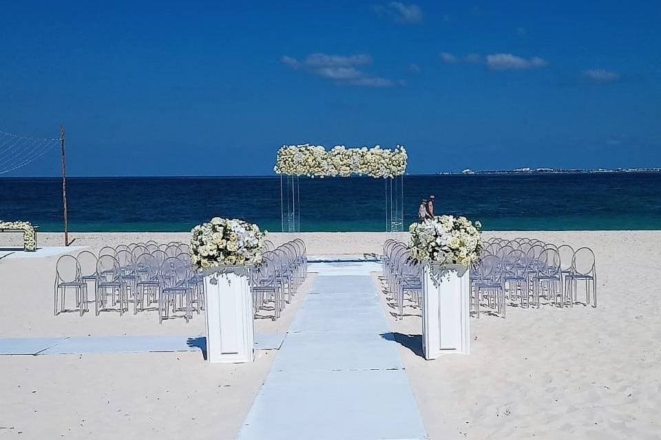 Ceremonia nupcial en la playa decorada con flores blancas