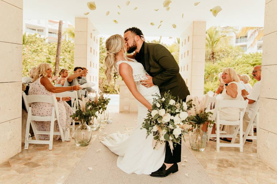 Novios besándose en el pasillo al altar