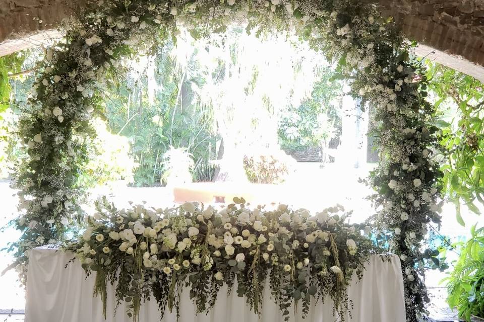 Mesa de novios con arco floral
