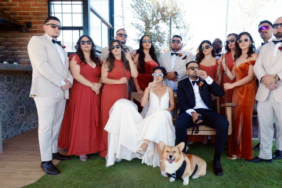 Novios posando con su perrito, damas de honor y bestmen