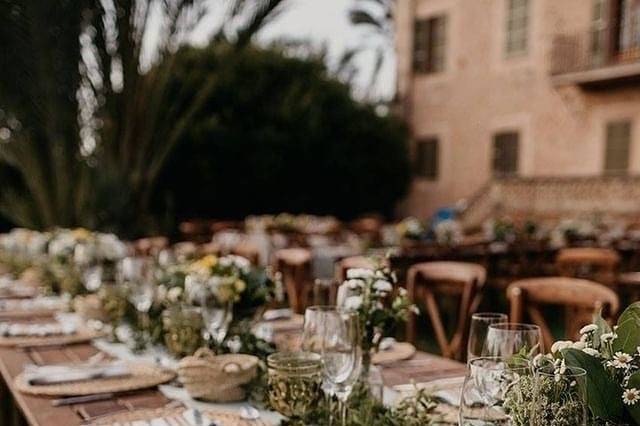 Mesa de madera con cubiertos y flores