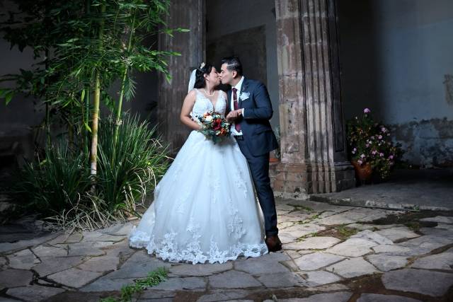 Novios dándose un beso en el patio en la noche