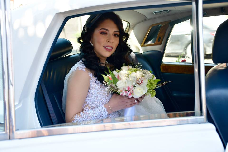 Novia sentada en el carro con su ramo