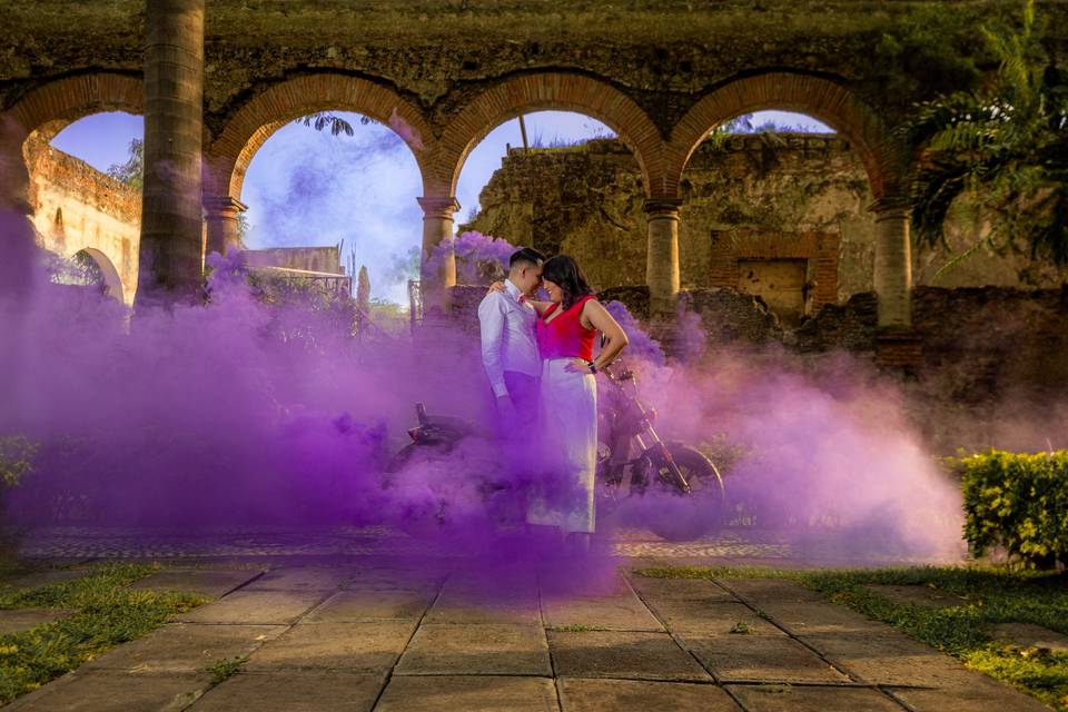 Pareja posando en una terraza rodeada de humo morado