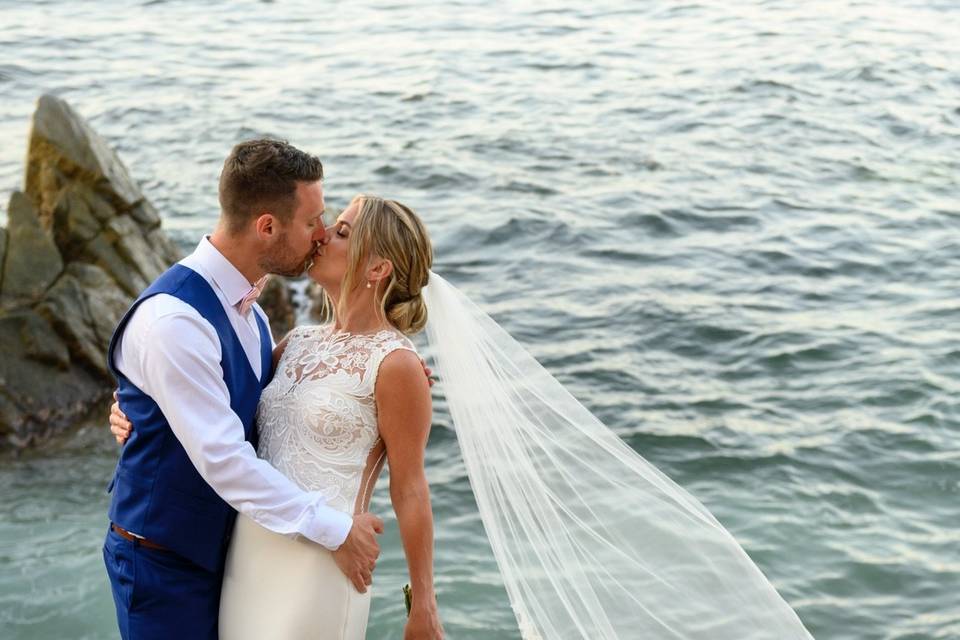 Novios besándose frente al mar