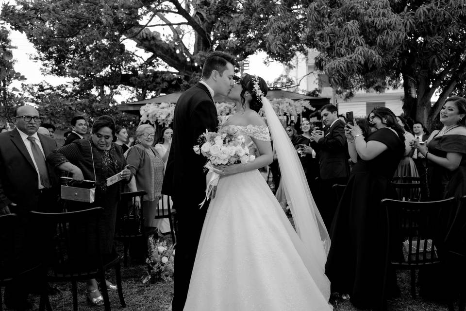 Novios besándose frente a sus invitados