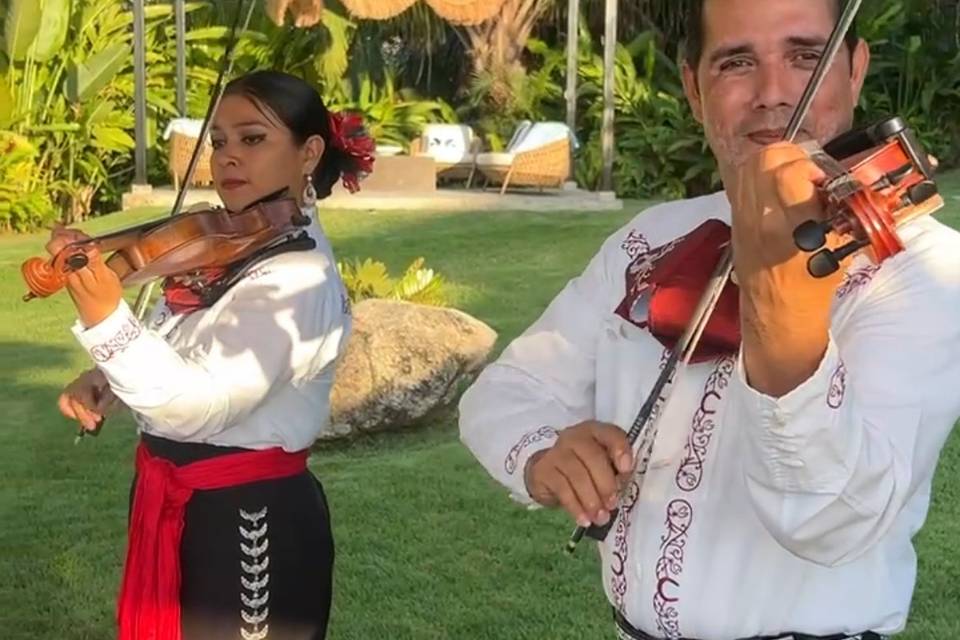 Dos músicos del mariachi tocando en el jardín