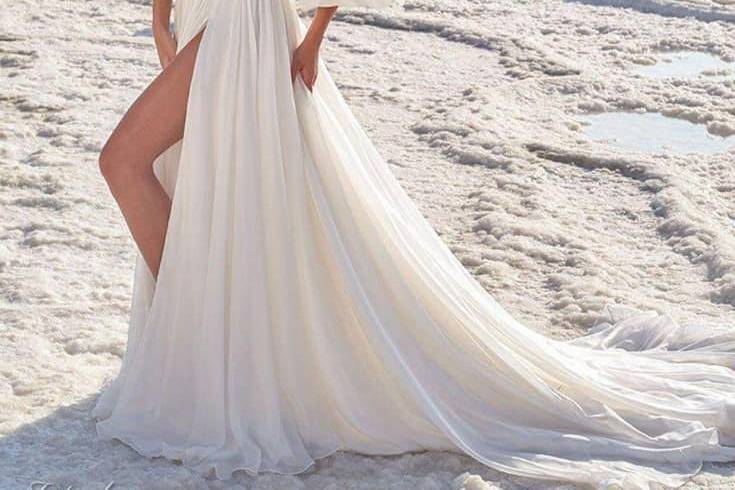 Novia en la playa con vestido de hombros caídos